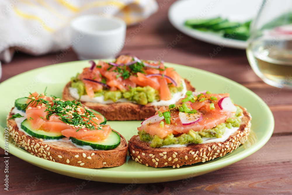 healthy sandwiches with salmon cucumber mashed avocado red onion dill on  plate  close up soft focus