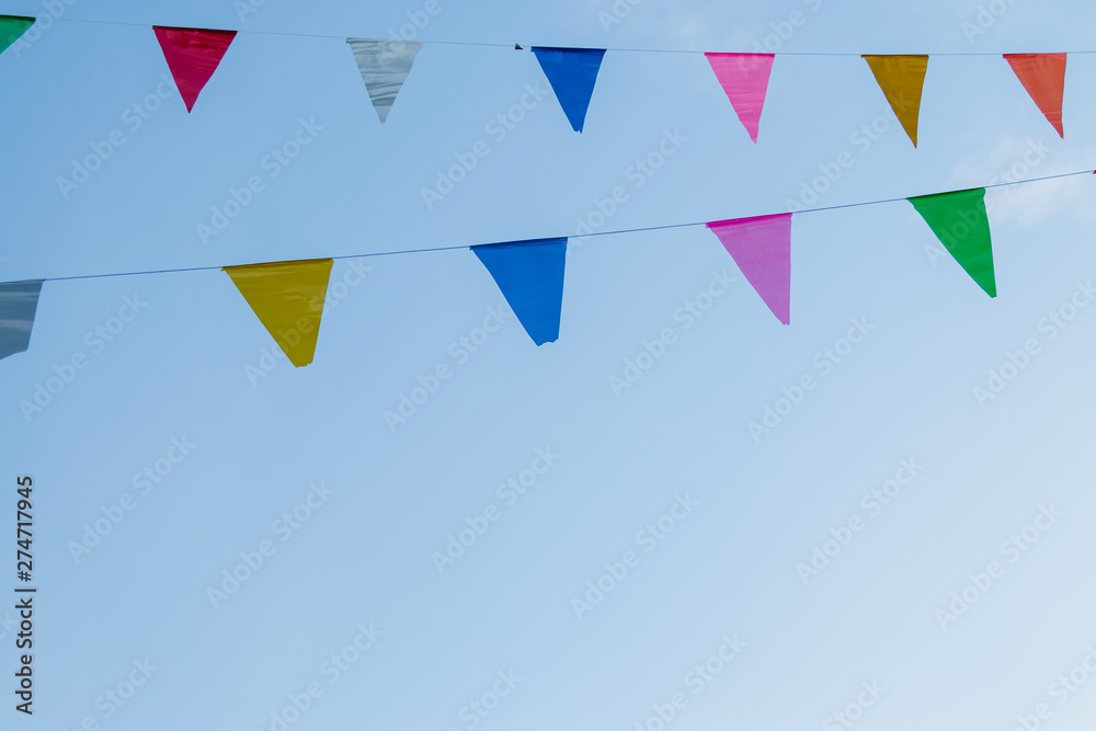 festival flag line with blue sky in background festival flag line with blue sky in background