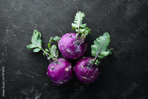 Purple kohlrabi cabbage. On a black stone background. Top view. Free space for your text. photo