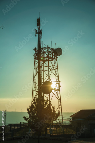 Silhouette of telecommunication tower on sunset