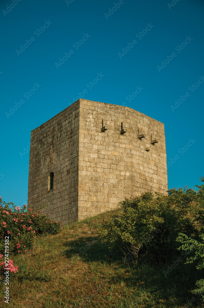 Stone square tower over rocky hill on sunset Stone square tower over rocky hill on sunset