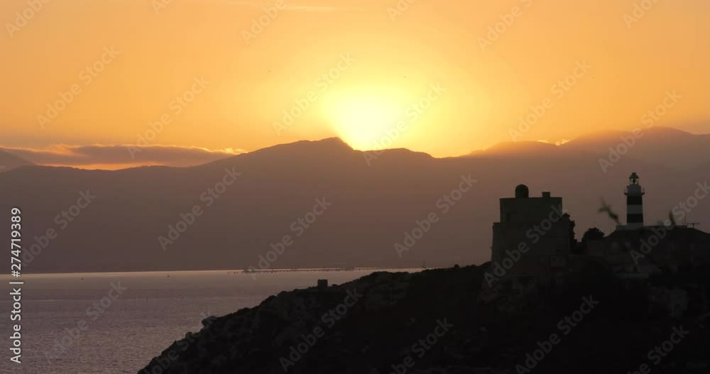 Sunset view on the lighthouse in Cagliari, Sardinia, Italy. Timelapse of sunset over silhouette mountains. Sunset view on the lighthouse in Cagliari, Sardinia, Italy. Timelapse of sunset over silhouette mountains.