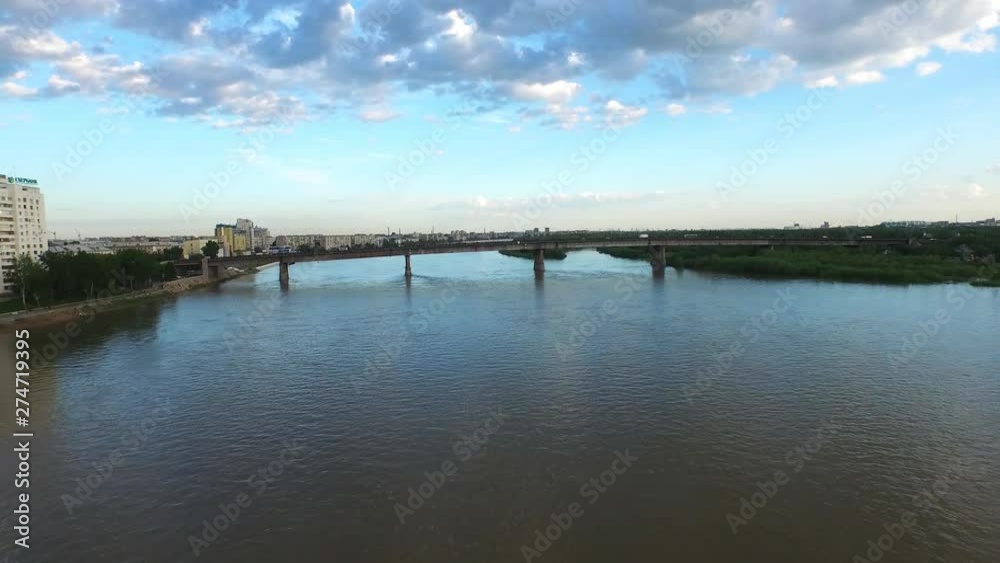 Aerial drone follow stacking shot of an empty garbage barge sailing across a river canal towards a bridge Aerial drone follow stacking shot of an empty garbage barge sailing across a river canal towards a bridge