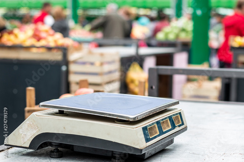Empty old scale on the marketplace counter in Belgrade. Blurred sellers and customers on background.