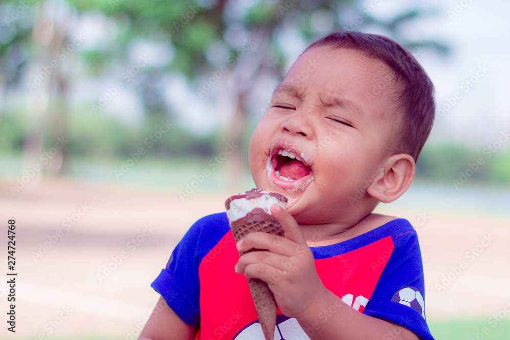 Cute Toddler boy Eating Ice-Cream. asian little children are happiness and funny in park at thailand Cute Toddler boy Eating Ice-Cream. asian little children are happiness and funny in park at thailand