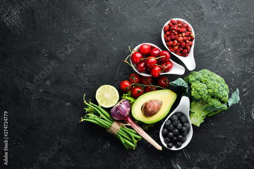 Fresh vegetables and fruits on a black background. Vitamins and minerals. Top view. Free space for your text.