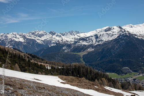 Panorama of high partly snowy mountains at blue sky taken from the Schatzalm-Davos in the swiss alps