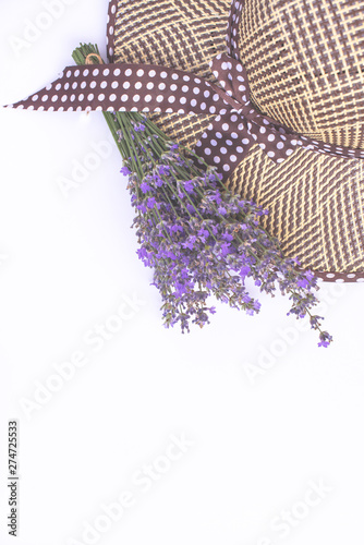 Bouquet of purple lavender and women's summer straw hat isolated on white top view. Flat lay, copy space. Vacation and relaxation concept.