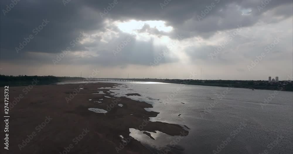 aerial drone shot : fly towards beams of sunlight through cloudy sky create a mysterious atmosphere over the Mekong river aerial drone shot : fly towards beams of sunlight through cloudy sky create a mysterious atmosphere over the Mekong river