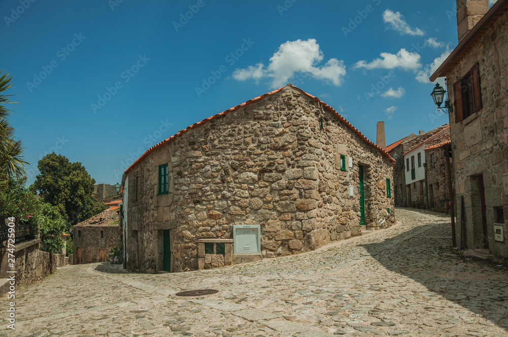 Corner of old stone house between two cobblestone alleys