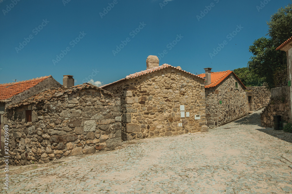 Cobblestone alley on slope and old stone houses
