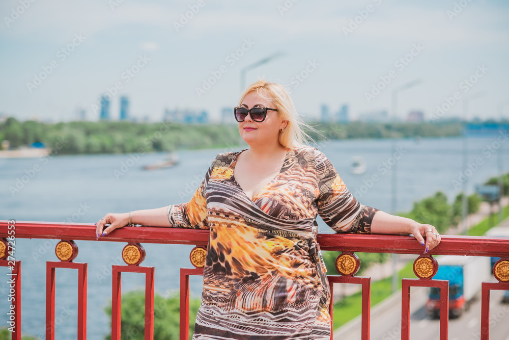 Pretty modern plus size lady lifestyle, woman’s beauty. Female XXL model with large size of figure posing outdoor 
