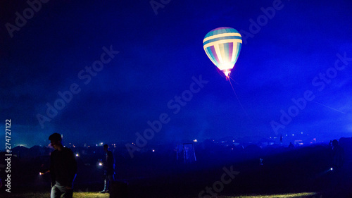 Hot air balloon flying over spectacular Cappadocia under the sky with milky way and shininng star at night (with grain) photo