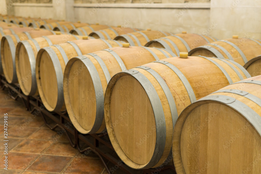 Wine barrels stacked in the cellar of the winery. Wine barrels in wine-vaults. Wine barrels stacked in the cellar of the winery. Wine barrels in wine-vaults.