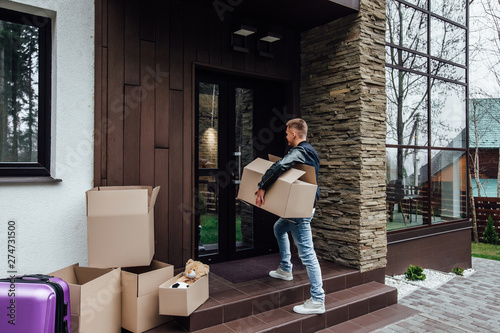 Moving. Young man with carton boxes in new apartment. © Тарас Нагирняк