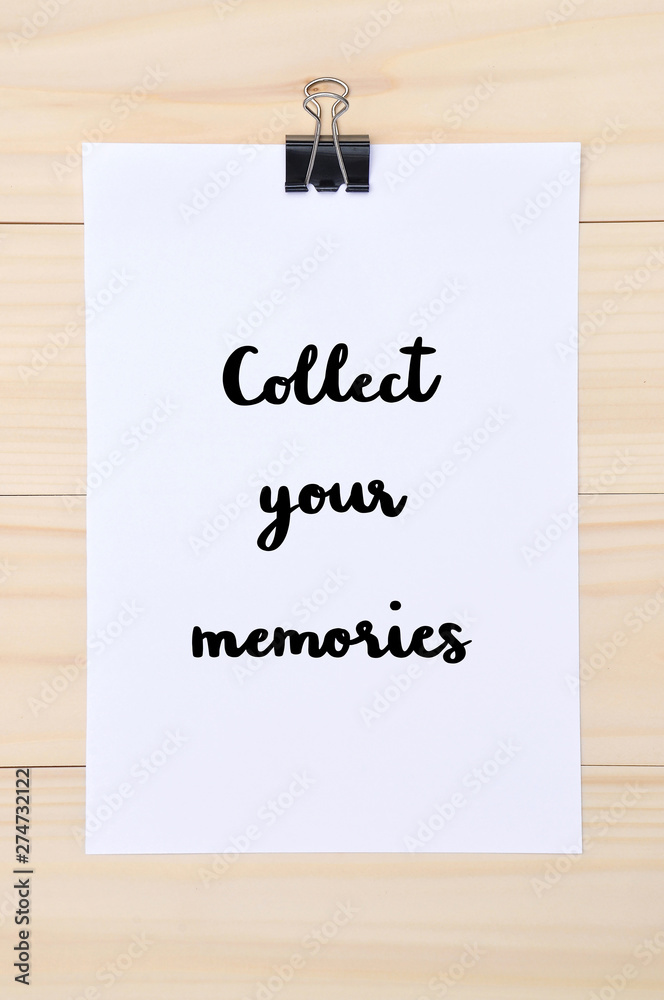 Collect your memories hand drawn lettering on white paper with wooden background Collect your memories hand drawn lettering on white paper with wooden background