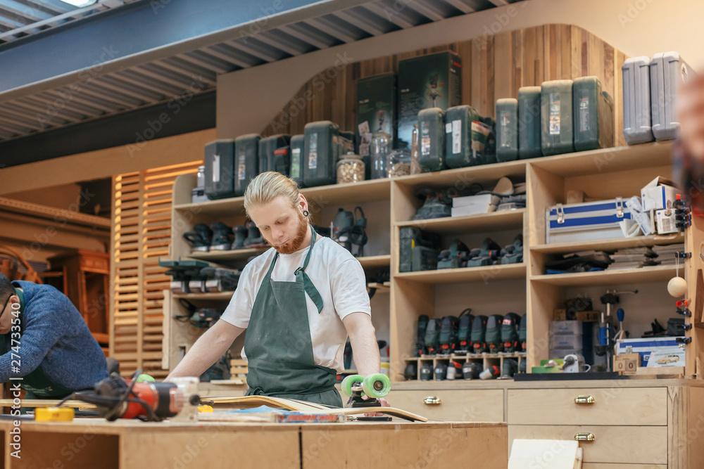 Hardworking middle aged professional male carpenter worker working on a new project in his workshop. Male work concept