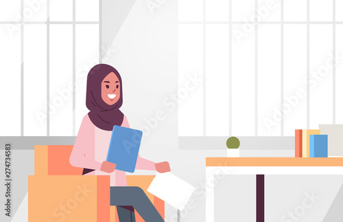 arabic businesswoman sitting at workplace desk arab business woman holding paper documents preparing report working process concept modern office interior flat portrait horizontal