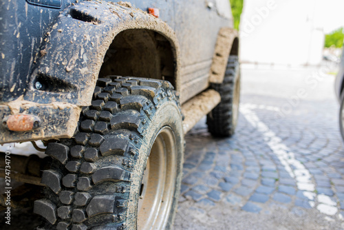 Off road tire close up shot on dirty 4 wheel drive car, shallow depth of field.