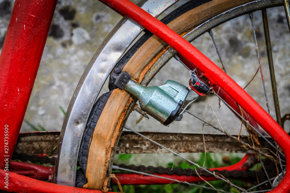 cropped shot of the rear wheel and dynamo of an abandoned and broken bicycle