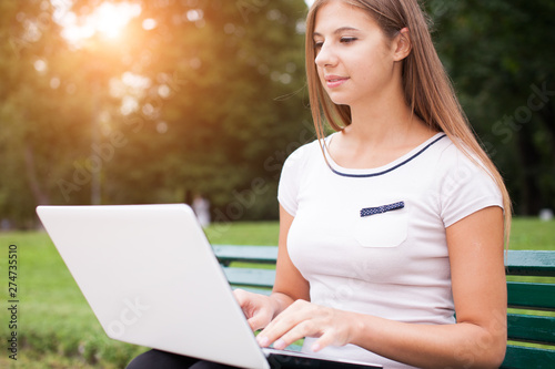 Young woman using her laptop outdoors