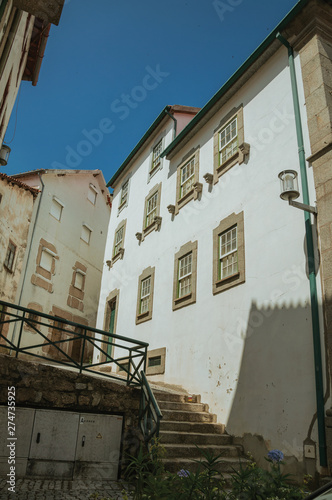 Whitewashed houses and staircase with railing on alley