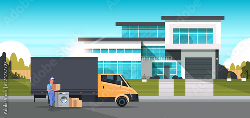 courier man near delivery truck with cardboard boxes washing machine domestic appliances store goods purchase distribution concept cottage house exterior full length horizontal