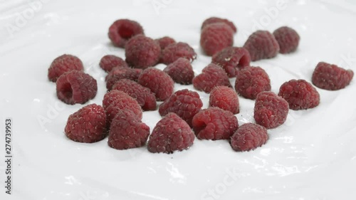 Raspberries roatating in yogurt photo