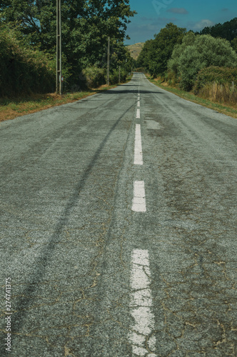 Deserted road passing through rural landscape