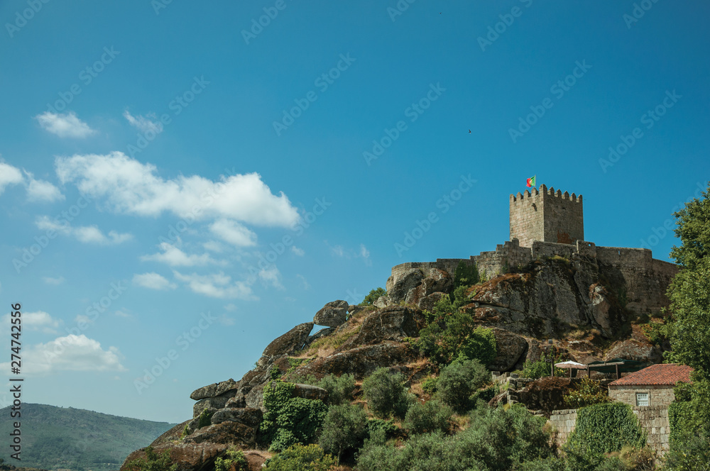 Hilly landscape with tower of castle over rocky cliff