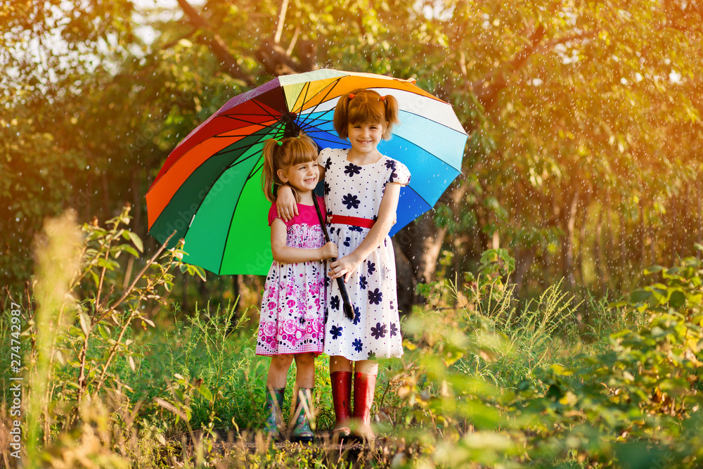 Fotografie Kids with colorful umbrella playing in autumn shower rain