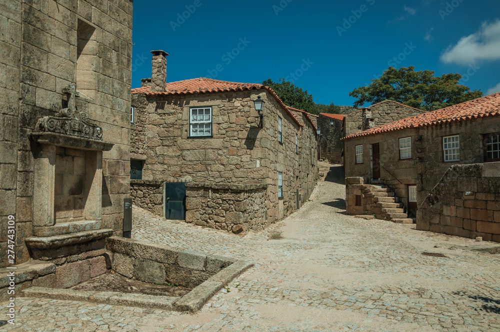 Houses made of stone with tree and deserted alley