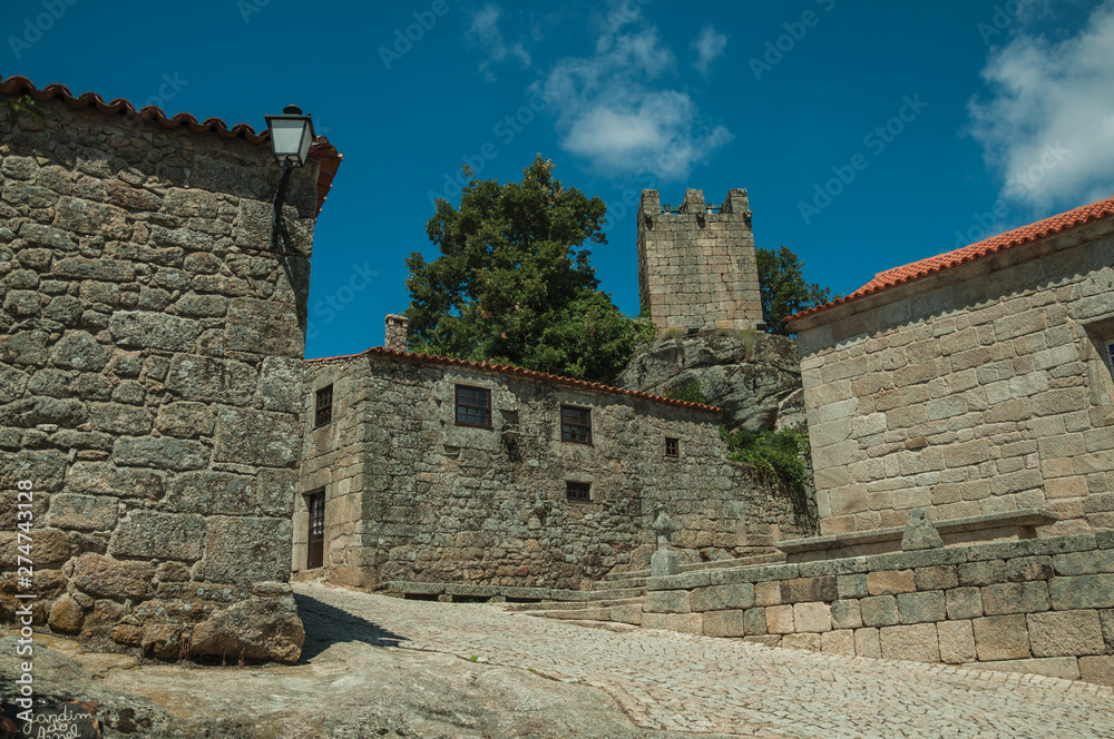 Houses made of stone with alley on slope and tower