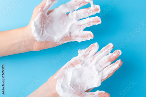 The hands of a teenager are treated with white cream