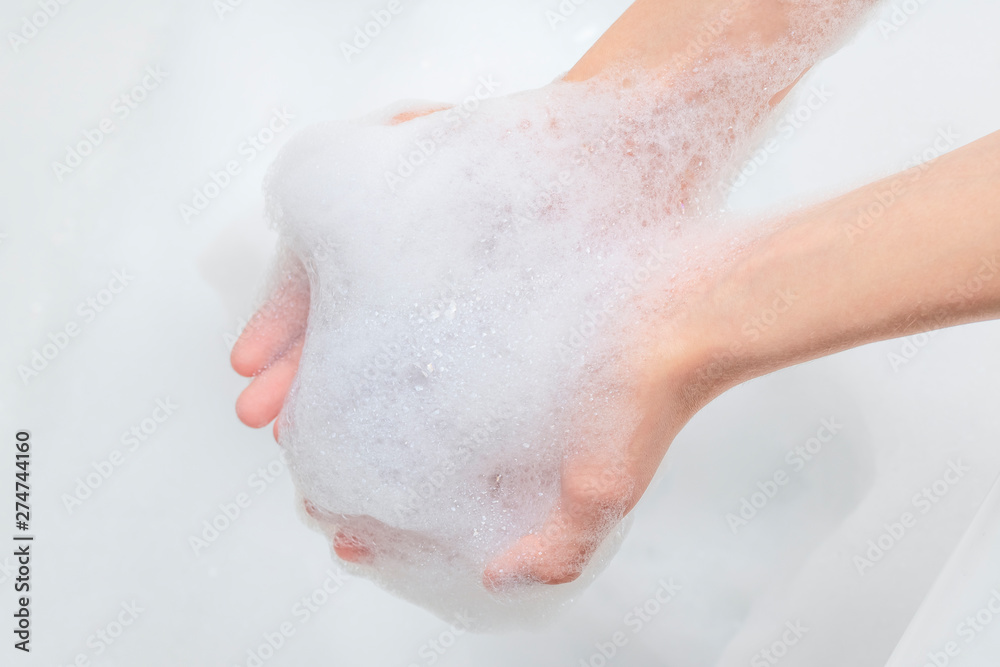 A pile of foam in the hands of a teenager in the bathroom A pile of foam in the hands of a teenager in the bathroom