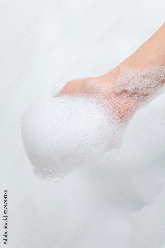 Hand with foam while bathing and cleaning the bathroom Hand with foam while bathing and cleaning the bathroom