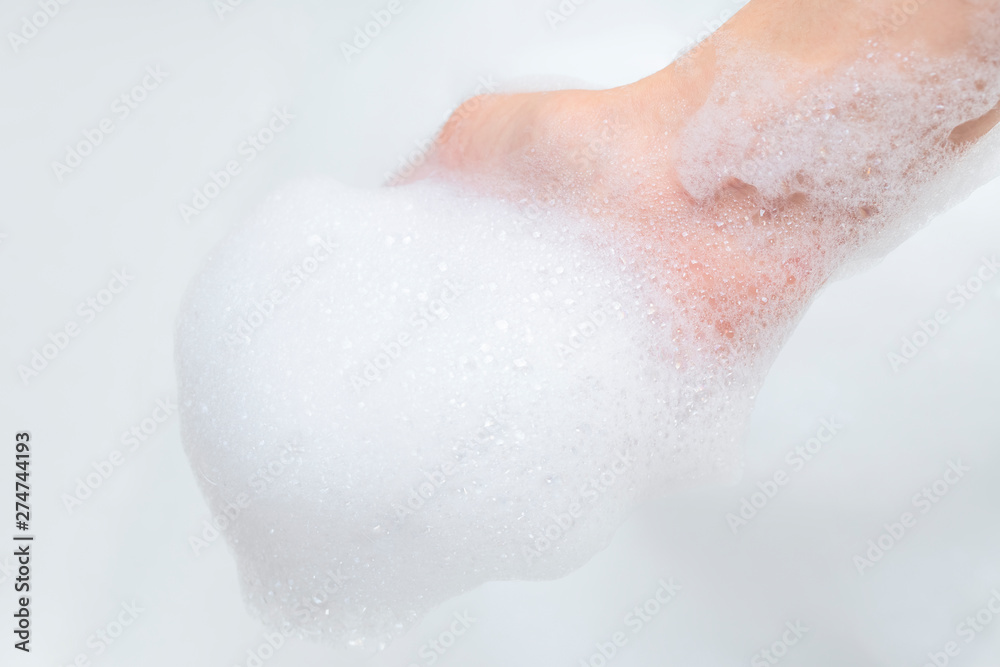 Fototapeta premium Hand with foam while bathing and cleaning the bathroom