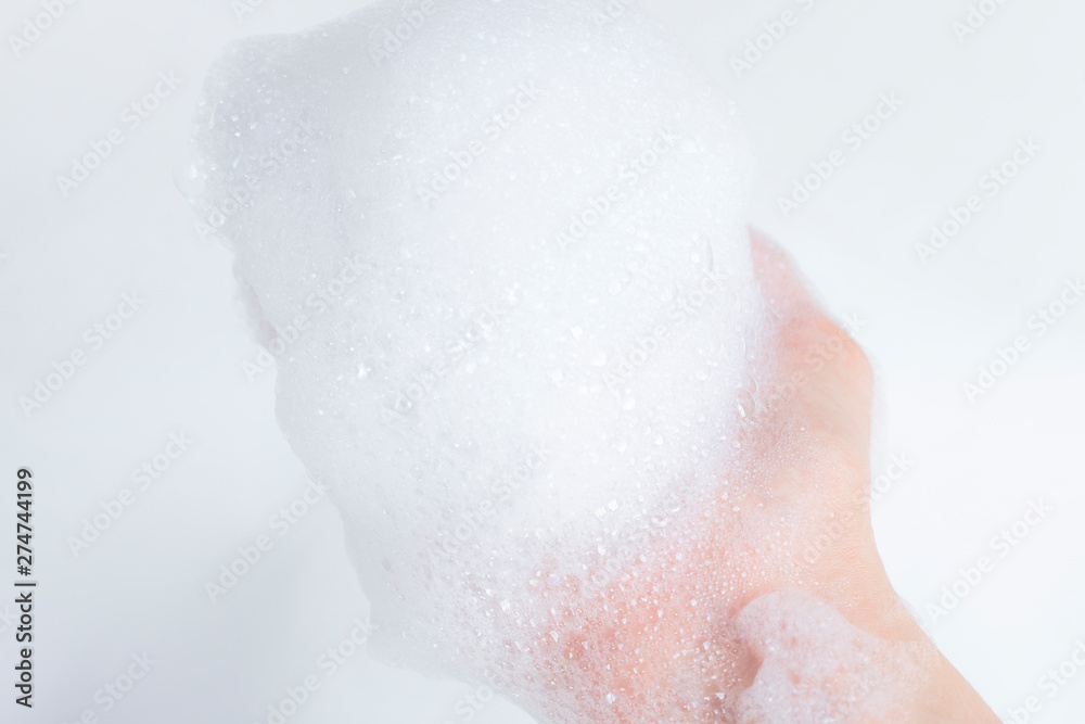 Fototapeta premium Hand with foam while bathing and cleaning the bathroom