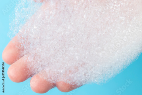 Foam with large bubbles in his hand on a blue background