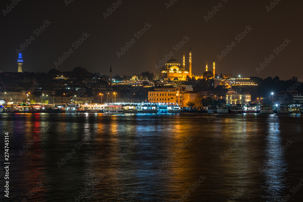 Istanbul night cityscape viewed form Galata Bridge with the illuminated Suleymaniye Mosque, Turkey