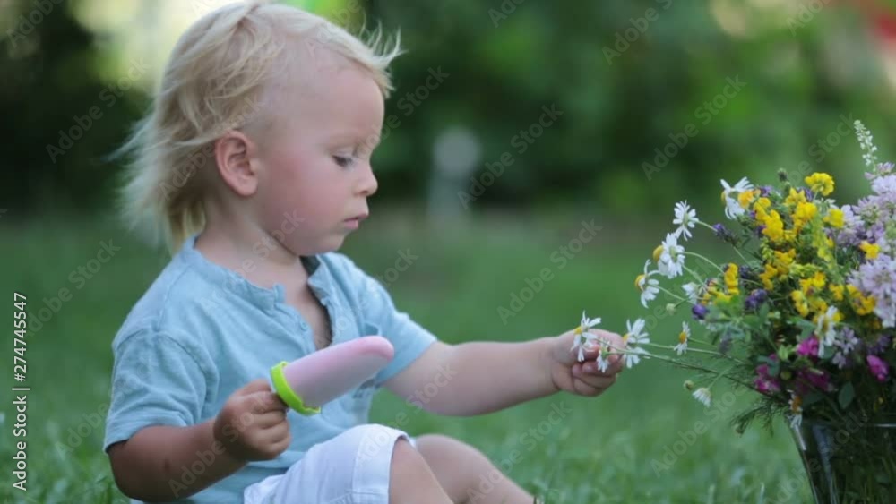 Cute blond toddler boy, eating homemade fruit ice cream Cute blond toddler boy, eating homemade fruit ice cream