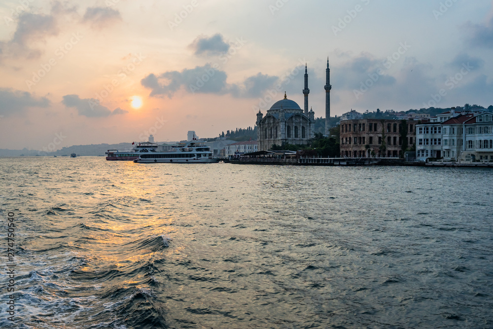Scenic view of Ortakoy Mosque at sunset from a ferry boat sailing the Bosphorus strait, Istanbul, Turkey