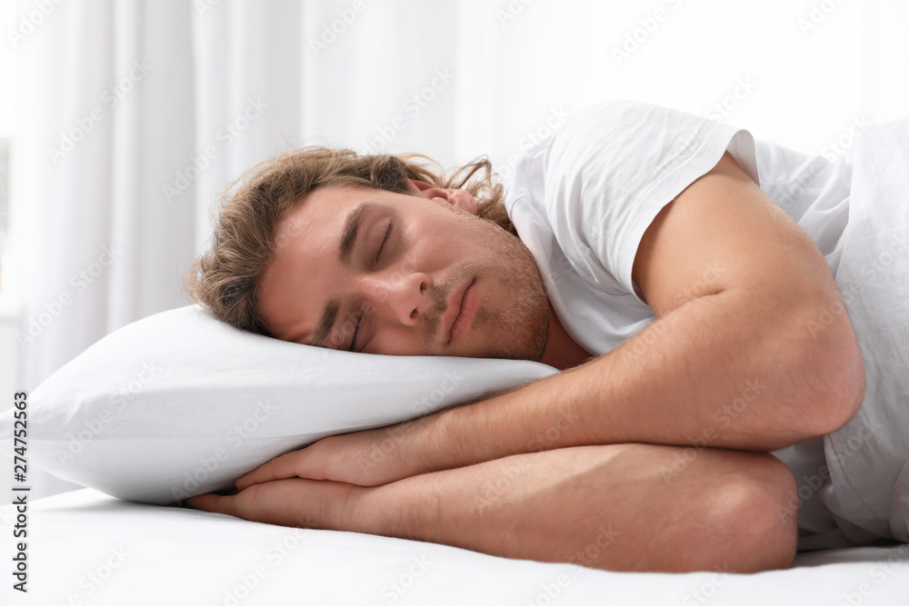 Handsome young man sleeping on pillow at home. Bedtime Handsome young man sleeping on pillow at home. Bedtime
