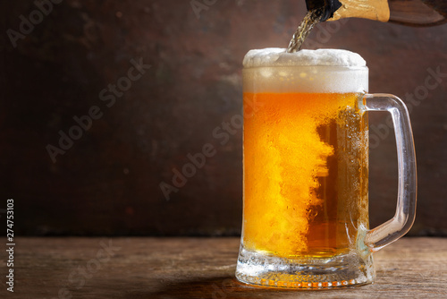 beer pouring from bottle into mug