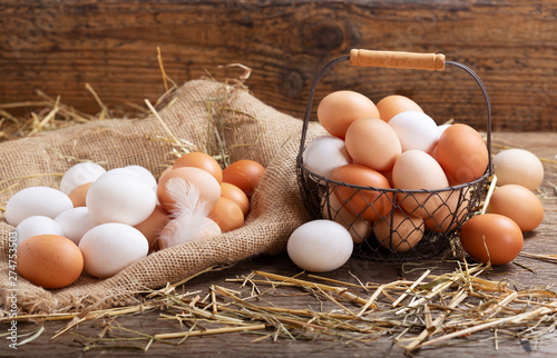 Obraz na płótnie basket of colorful fresh eggs on wooden table