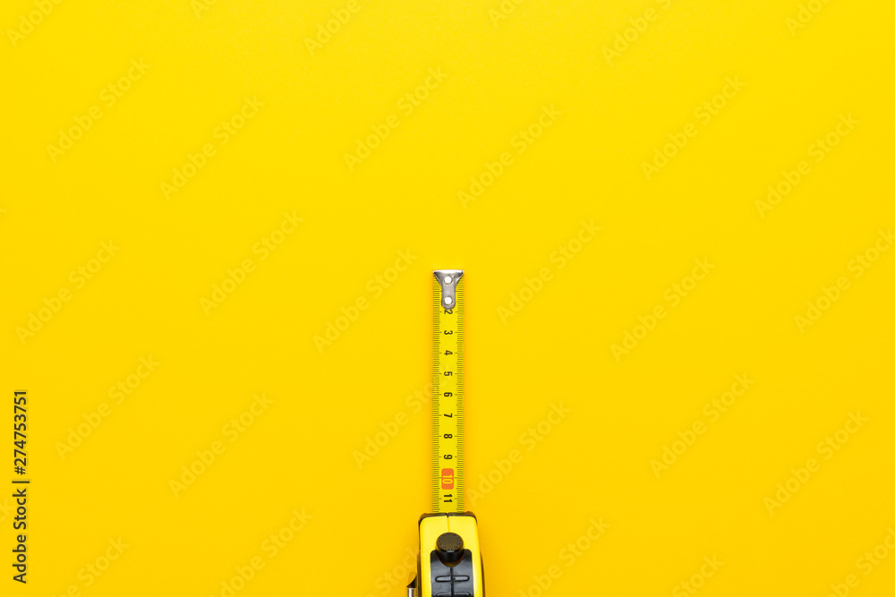tape measure on the yellow background with copy space. minimalist photo
