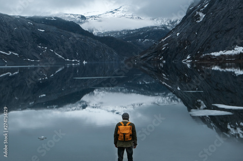 Fototapeta travel and adventure background, hiker with backpack enjoying landscape in Lofot