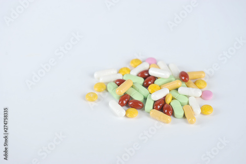 Medications or drugs in the form of tablets, of various sizes, shapes and colors. Tablets for oral administration on a white background. Close-up. Free space to place text.