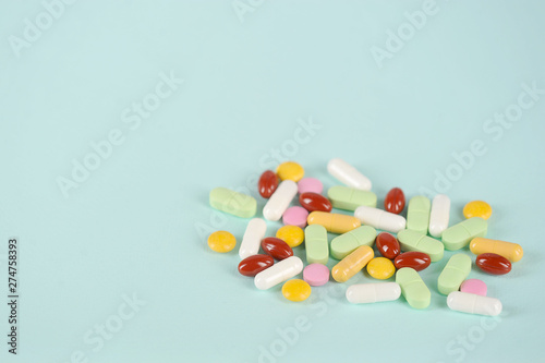 Medications or drugs in the form of tablets, of various sizes, shapes and colors. Tablets for oral administration on a light background. Free space to place text.