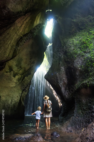 Mother with son near waterfal on Bali, Indonesia 